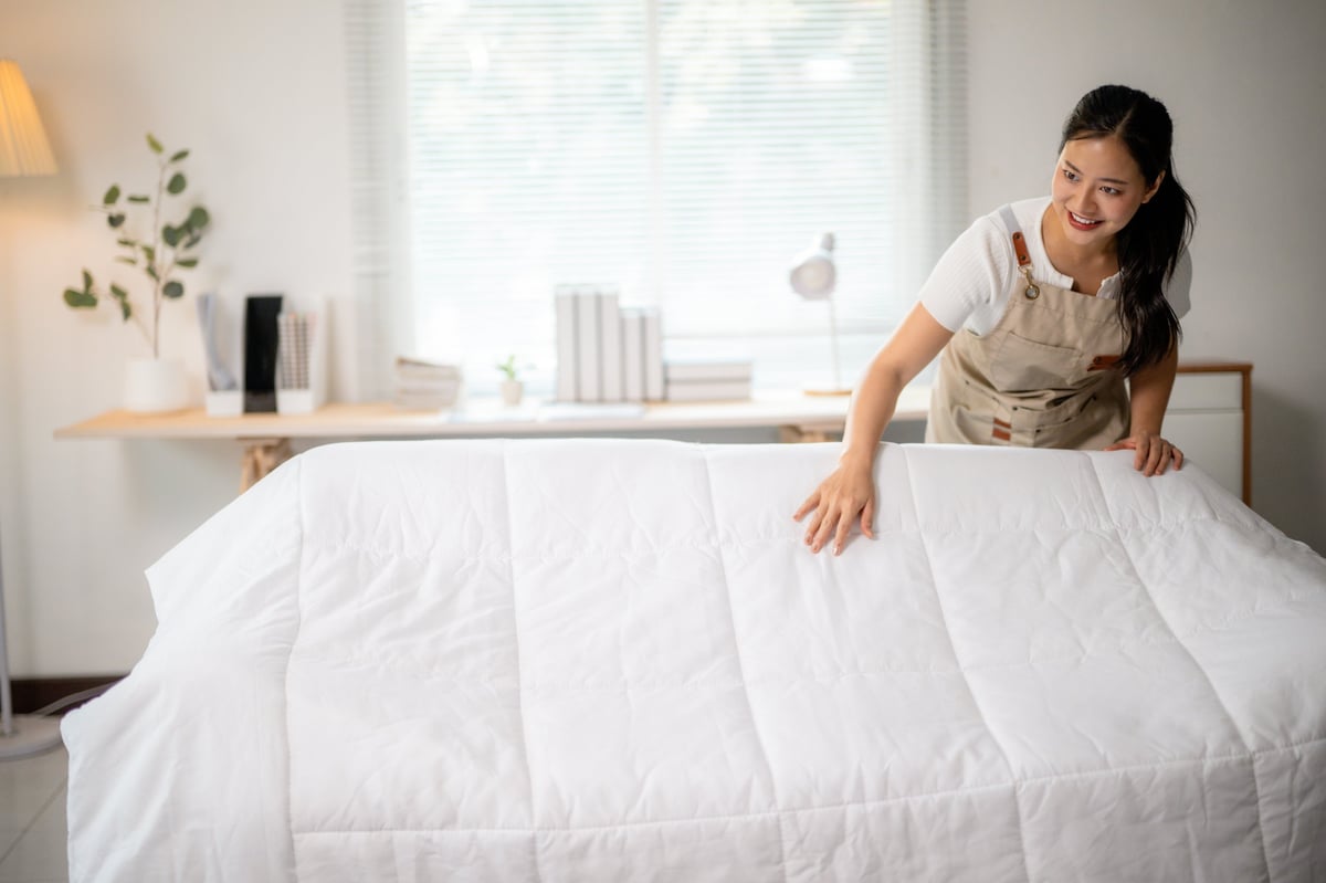 Professional cleaner preparing fresh linens for a vacation rental turnover